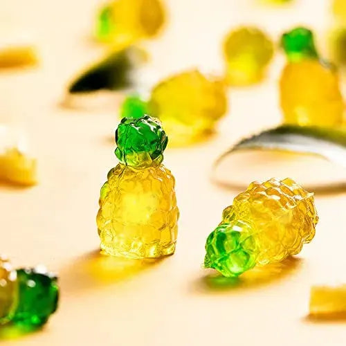 Gummy pineapple candies on a reflective surface with a blurred background