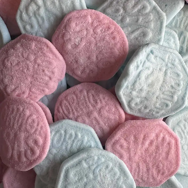 Close-up of pink and gray hexagonal cookies with embossed designs.